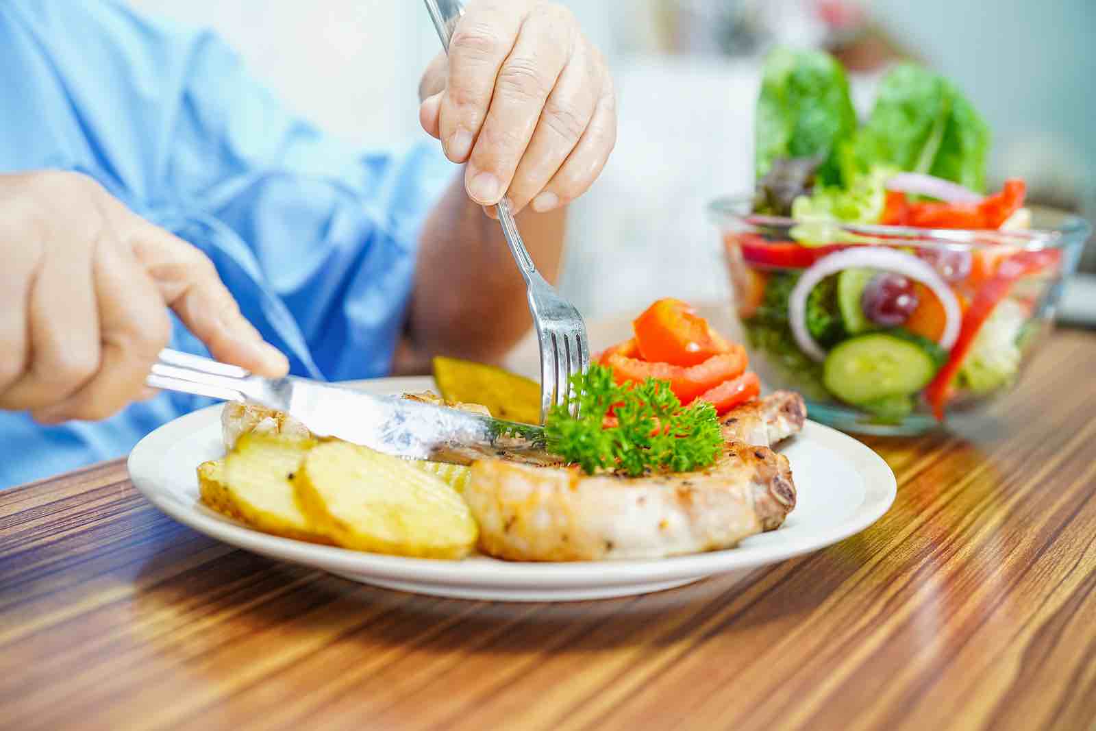 An older adult eating a healthy summer meal.