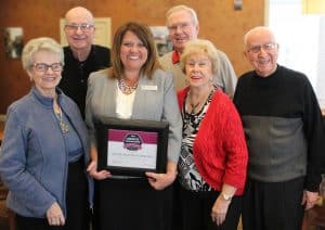 Silver Maples President and CEO Julie Deppner, with five seniors from our leadership committee, holding a plaque from our Holleran Senior Community Choice Award.
