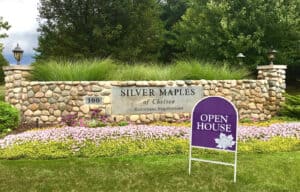 Open House banner placed in front of the stone sign at Silver Maples' main entrance