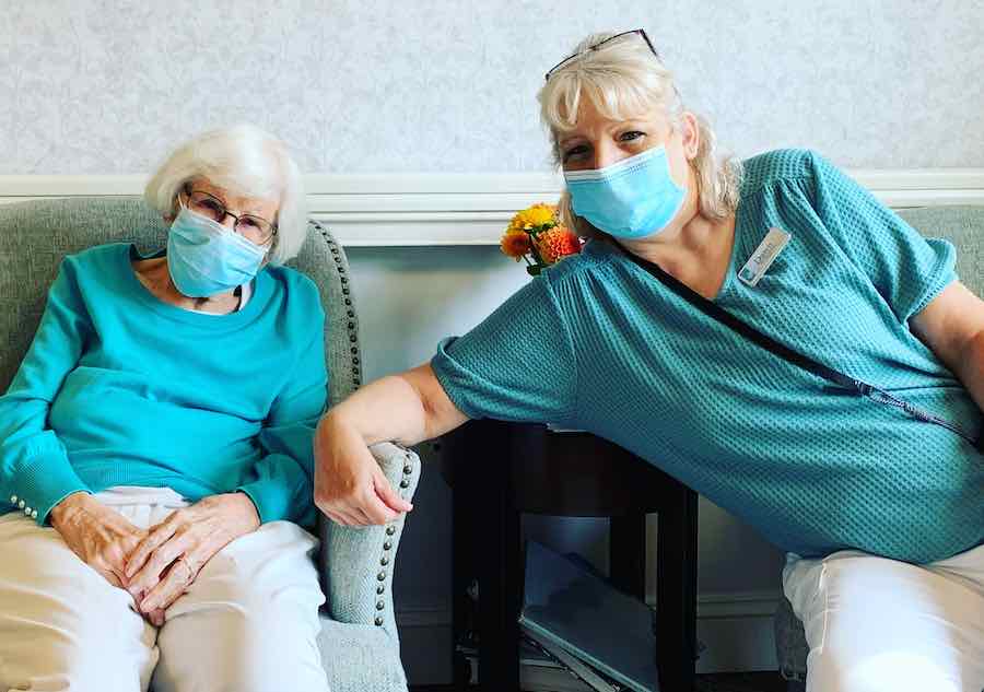 A woman in a senior living retirement community sitting inside to social distance and protect herself from COVID-19.