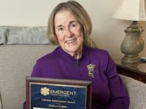Kathleen Griffiths holding lifetime achievement award plaque