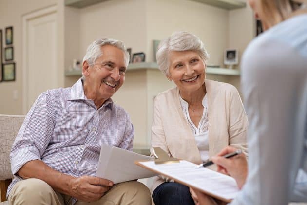 A senior couple works together with a non-profit senior living community representative.