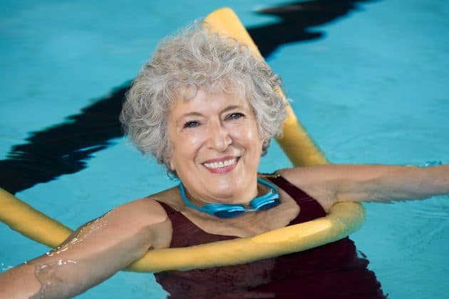 Active older woman enjoys pool exercises for seniors.