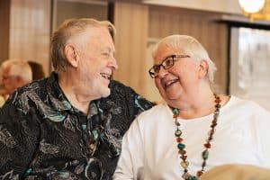 Elderly couple sitting close together indoors