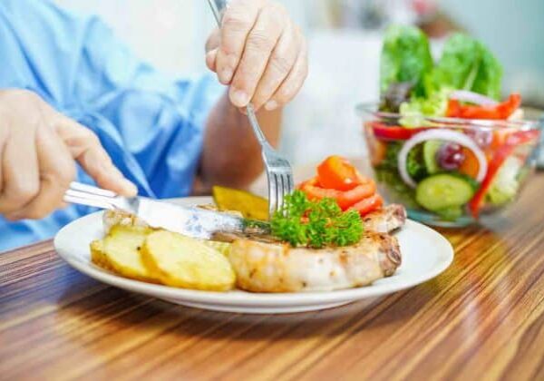 An older adult eating a healthy summer meal.