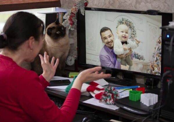 An older woman on a video call with her son and grandson during the holidays.