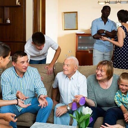 Friendly large multiethnic family meeting in cozy living room, enjoying communication with each other