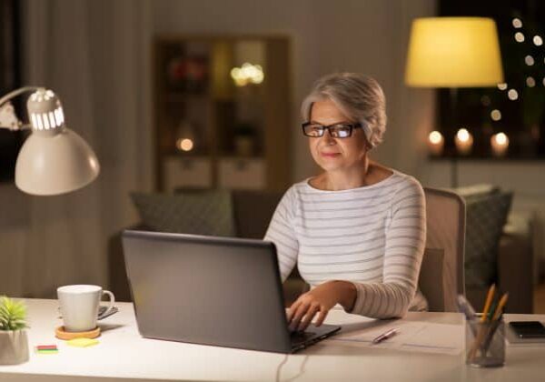 A senior citizen woman participating in an online volunteer opportunity from her own home.