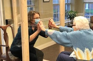 Family using visiting booth at Meadows Assisted Living during COVID-19